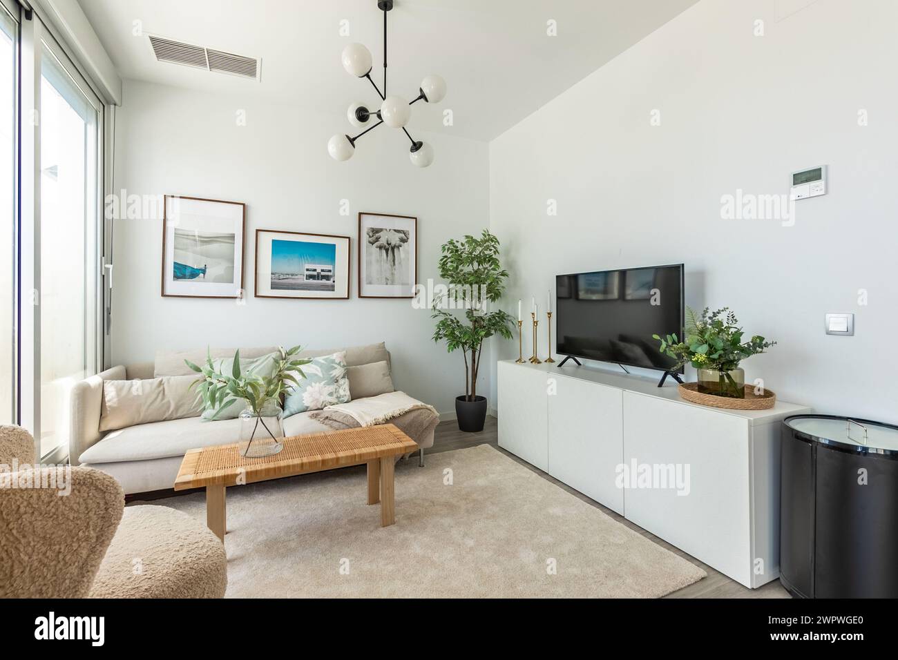 un'immagine di un'area soggiorno con divano e televisione in una proprietà immobiliare mediterranea Foto Stock