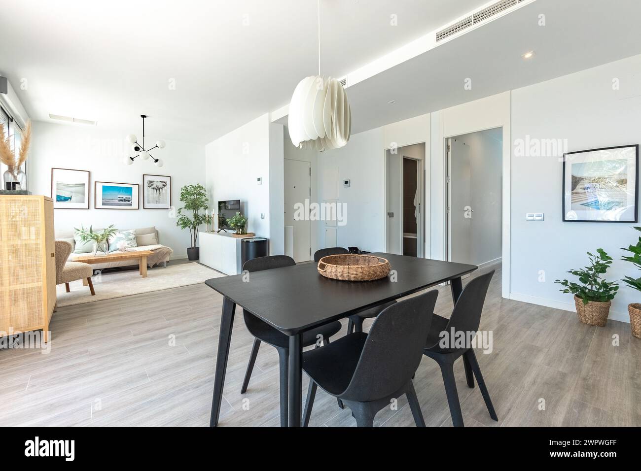 un'immagine di un tavolo da pranzo nero in un grande soggiorno aperto in un lussuoso complesso residenziale mediterraneo Foto Stock