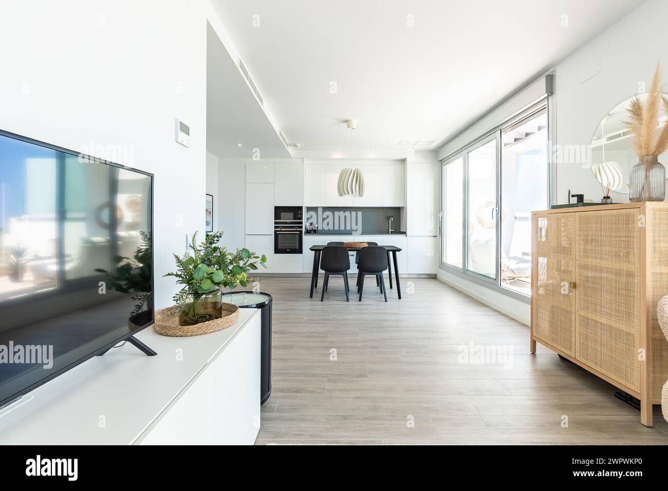 una lussuosa area soggiorno e sala da pranzo all'aperto con cucina completa e terrazza con balcone nell'immobiliare mediterraneo Foto Stock