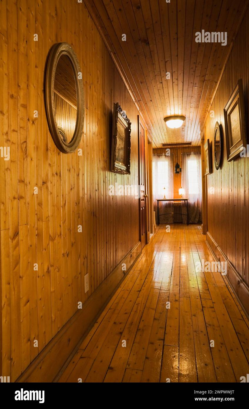 Corridoio con pavimento in legno duro al piano superiore all'interno di una vecchia casa a due piani degli anni '1920. Foto Stock