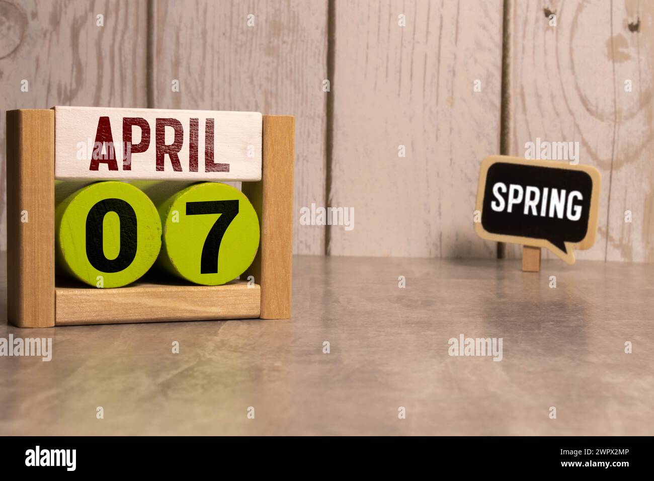 Aprile 07st. Giorno 07 del mese, il calendario giornaliero sul tavolo bianco con la riflessione, con luce sfondo blu. Il tempo primaverile, spazio vuoto per il testo Foto Stock
