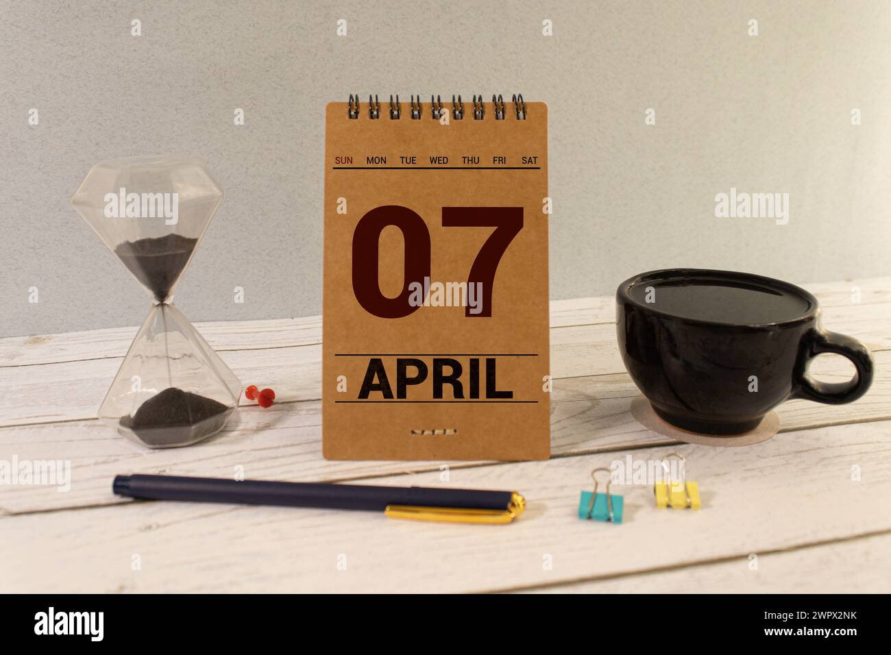 Aprile 07st. Giorno 07 del mese, il calendario giornaliero sul tavolo bianco con la riflessione, con luce sfondo blu. Il tempo primaverile, spazio vuoto per il testo Foto Stock