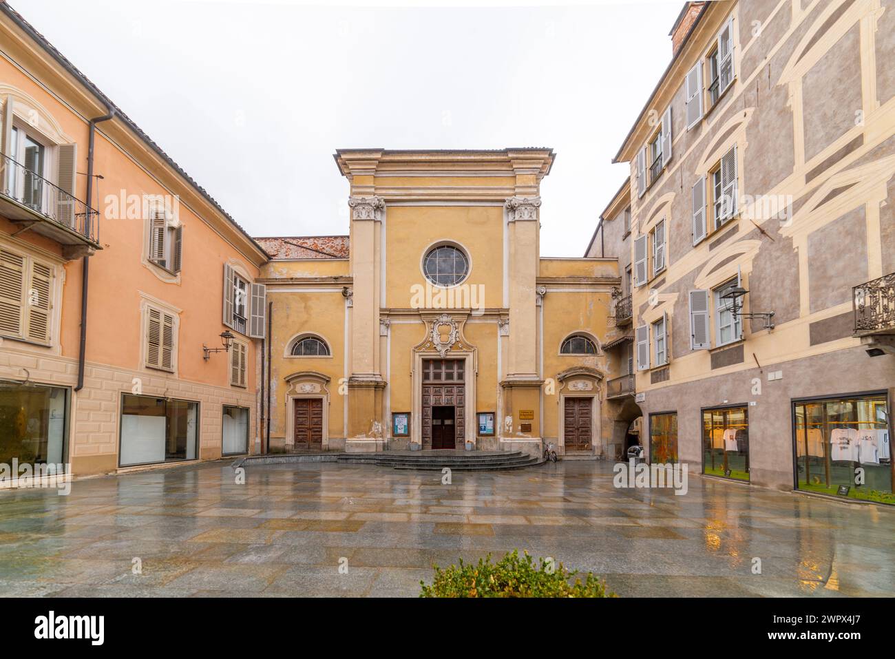 Mondovi, Italia - 09 marzo 2024: Chiesa di San Augustine su St Augustine Street con edifici storici in una piazza lastricata Foto Stock