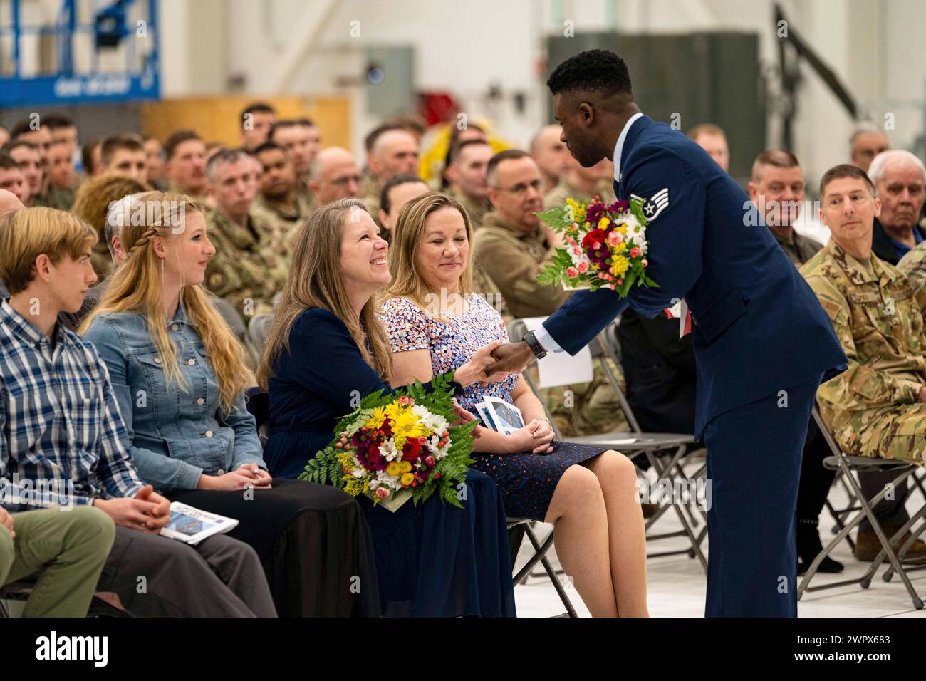 2 marzo 2024 - Pittsburgh Airport Air Reserve S, Pennsylvania, USA - Sgt. Dieudonne Mofor, 911th Civil Engineering Squadron Operations manager, presenta fiori alla famiglia del comandante in arrivo durante un'assunzione del comando, presso la Pittsburgh International Airport Air Reserve Station, Pennsylvania, 2 marzo 2024. Il personale militare spesso presenta le proprie famiglie con fiori durante le cerimonie come un gesto simbolico di apprezzamento e amore, riconoscendo il loro sostegno incrollabile e sacrifici che rimangono in gran parte invisibili ma sono parte integrante della forza e della dedizione del membro del servizio. Foto Stock