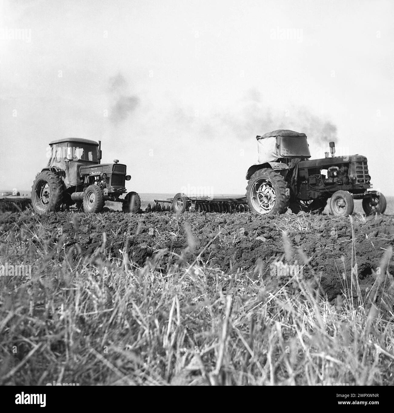 Una cooperativa agricola statale (C.A.P.) nella Romania comunista, negli anni '1970 Trattori che arano un campo. Foto Stock