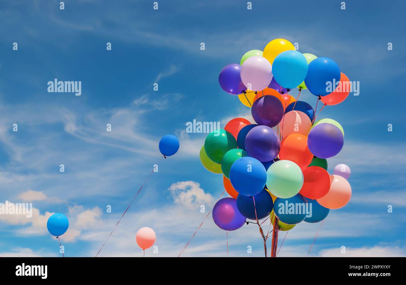 Un gruppo di palloncini colorati all'aperto in una giornata nuvolosa Foto Stock