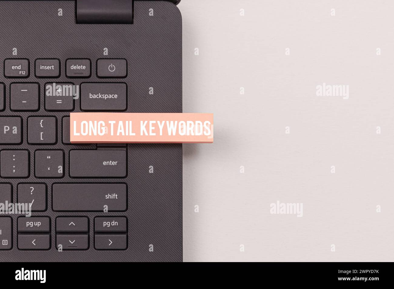 Vista ravvicinata della tastiera del notebook che evidenzia il concetto di parole chiave a coda lunga Foto Stock