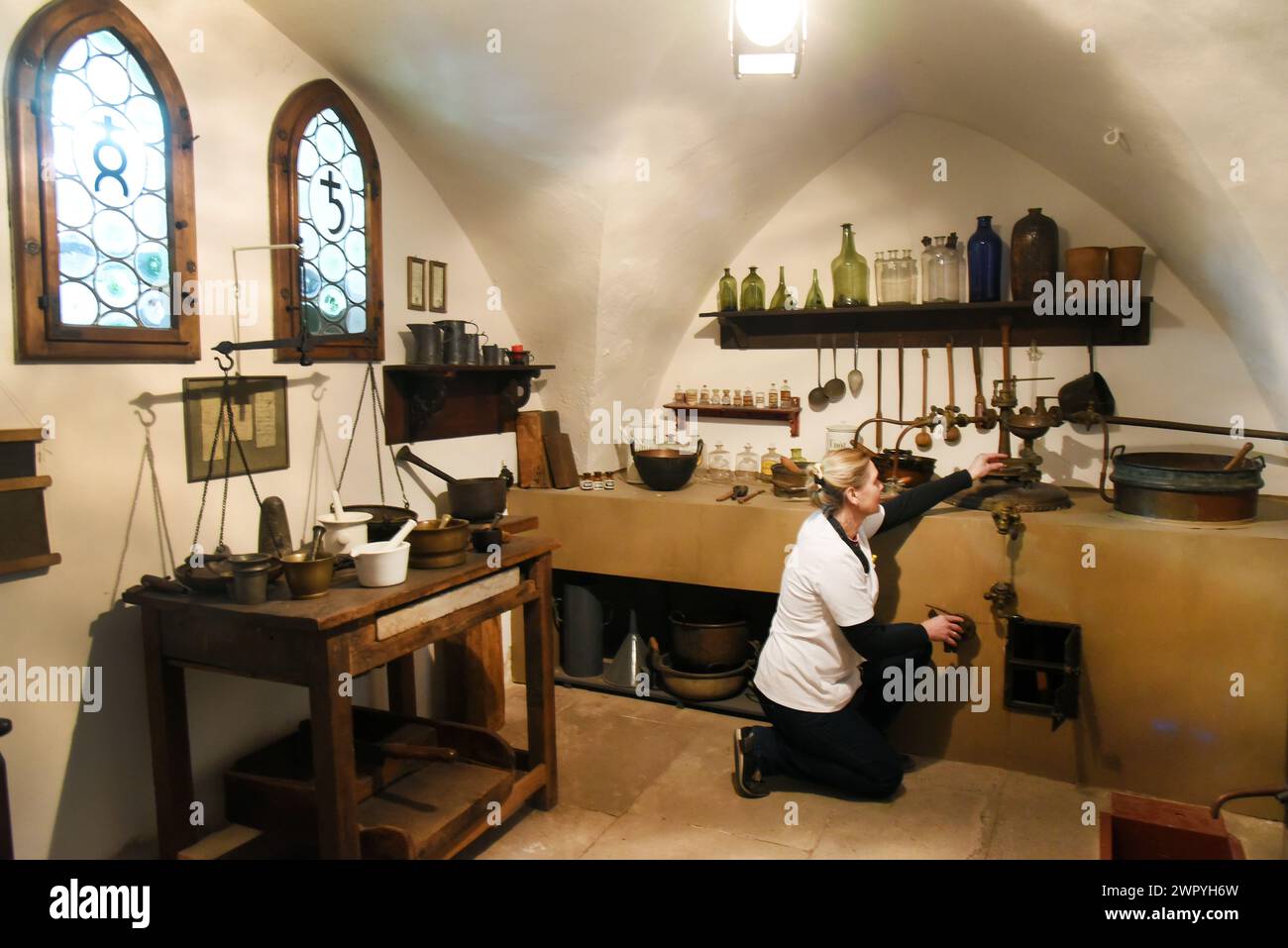 29 febbraio 2024, Sassonia-Anhalt, Naumburg: Nel museo della storica farmacia Löwen, il farmacista Kerstin Reh dimostra la produzione di estratti e unguenti in una vecchia volta utilizzando attrezzature del XVII secolo. La farmacia, gestito dalla famiglia del direttore della farmacia Dr. Andreas Hünerbein da 120 anni, è uno dei pochi stabilimenti del suo genere in Germania che si trova nello stesso luogo da oltre 400 anni e da cui molti oggetti possono essere esposti in un museo. Le mostre del museo includono il privilegio di farmacia del 1635 emesso dall'Elettore di Sassonia, Johann G. Foto Stock