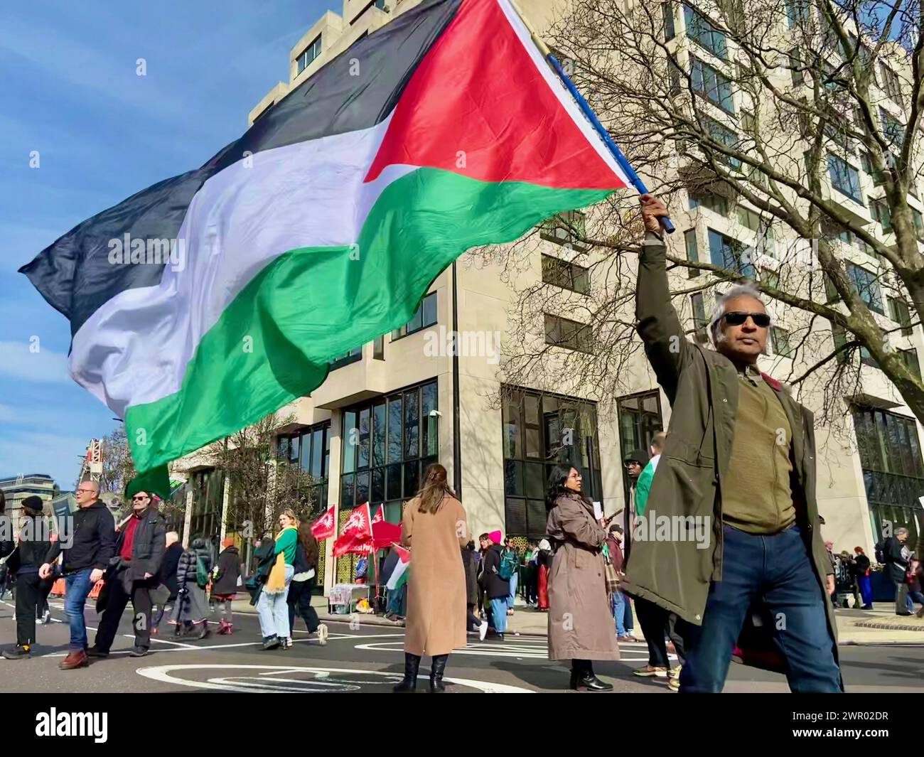 i manifestanti con slogan e bandiere palestinesi alla fine della guerra a gaza in modo pacifico e non aggressivo attraversano londra il 9 marzo 2024 Foto Stock