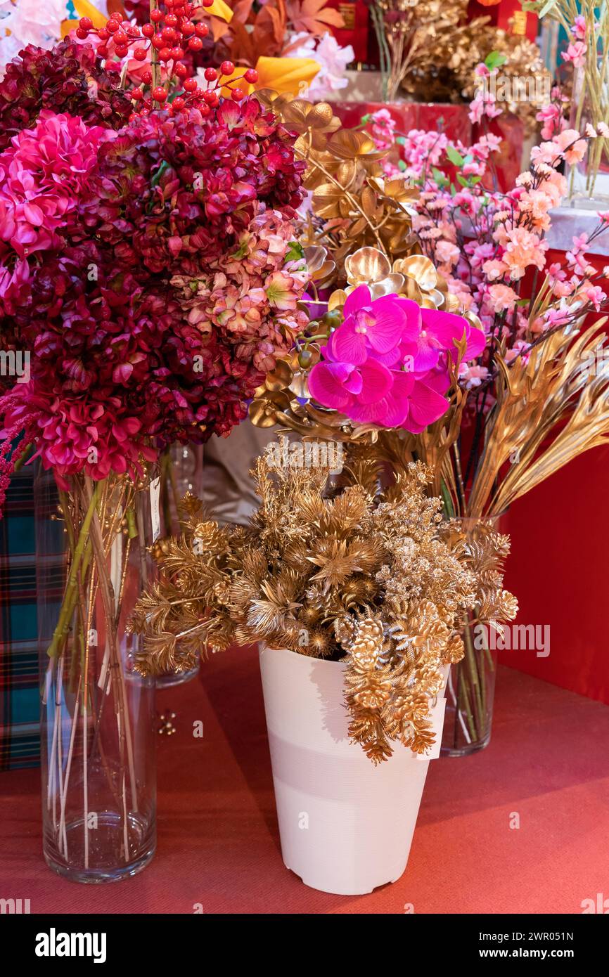 Diversi tipi di decorazioni colorate di fiori artificiali in vendita. Foto Stock