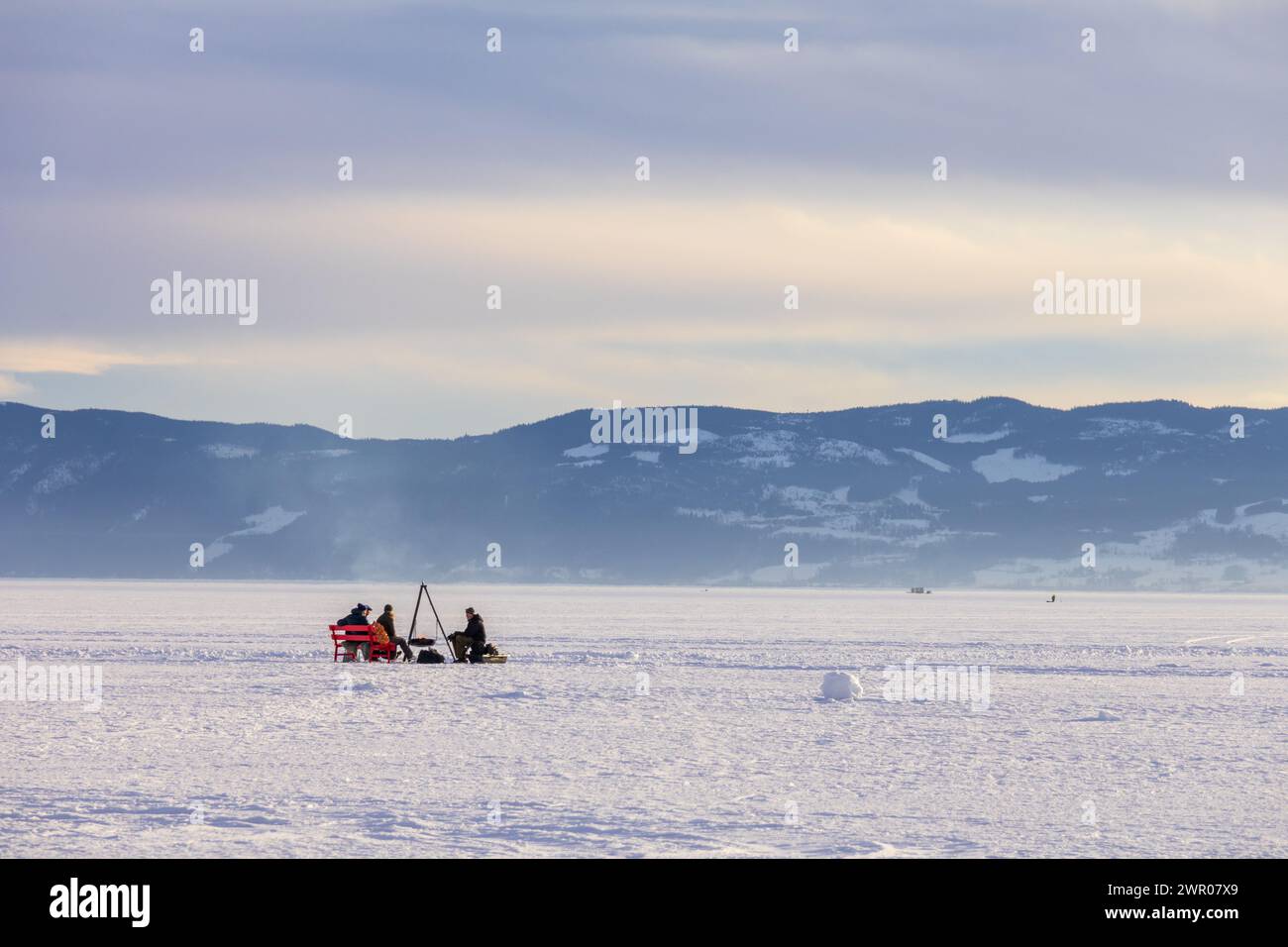 Persone su un lago ghiacciato intorno a un caminetto Foto Stock