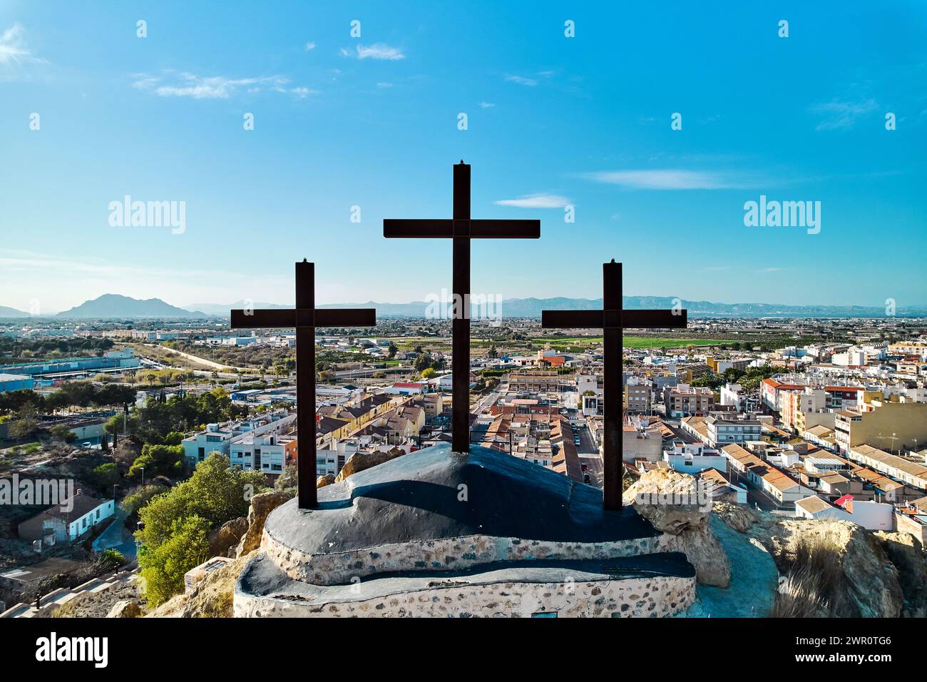 Vista aerea del paesaggio cittadino di Rojales con Monte Calvario e tre croci contro il cielo blu. Rojales, città, Spagna Foto Stock