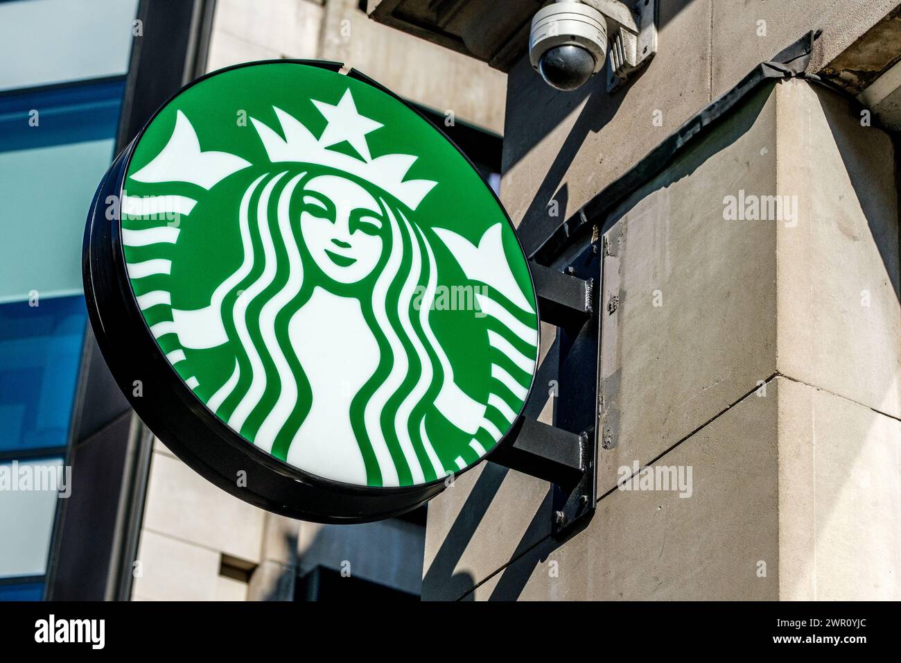 Soho, Londra, Regno Unito, 8 marzo 2024, logo Starbucks Coffee Shop con telecamera di sicurezza e Nessuna persona Foto Stock