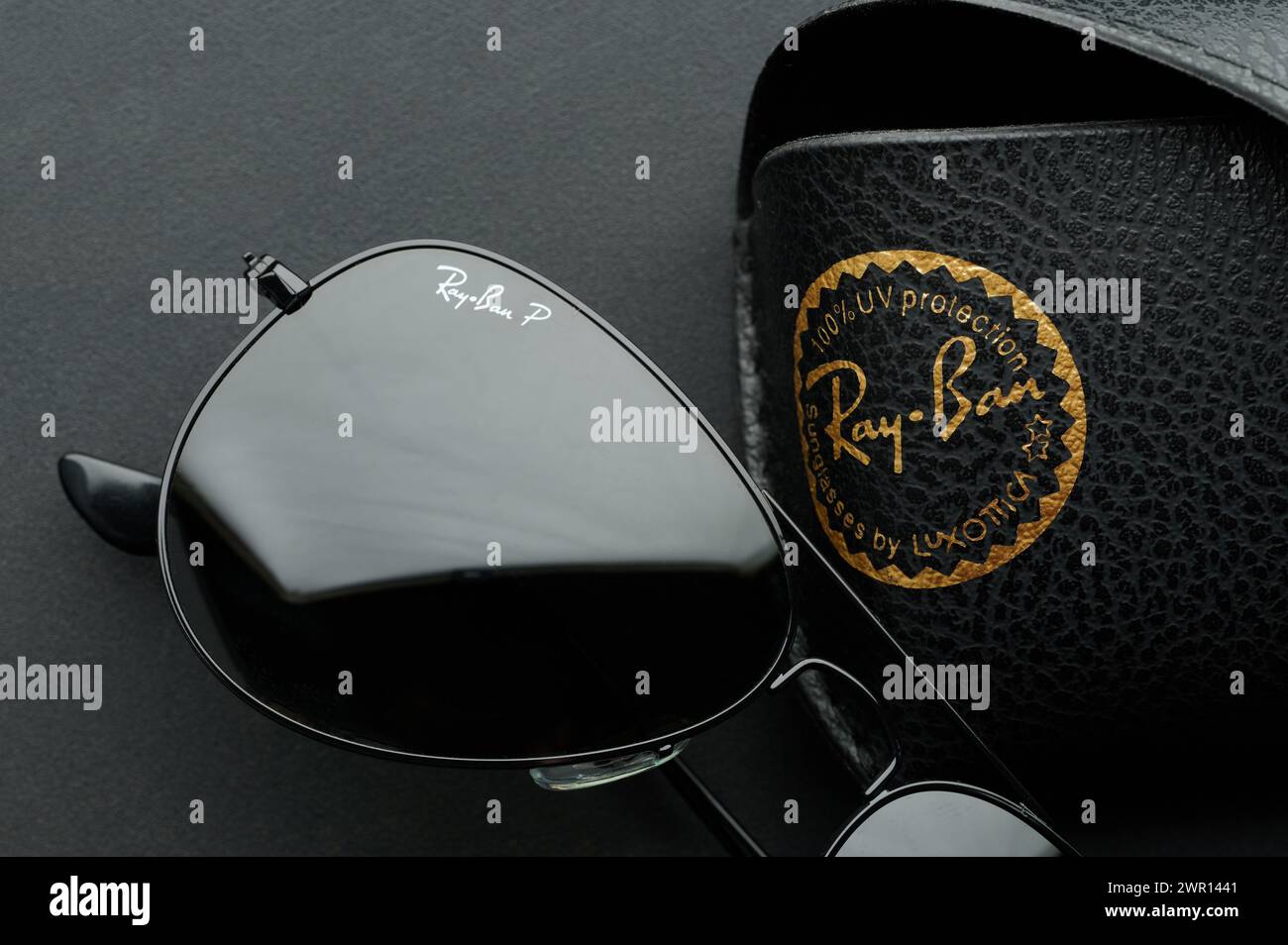 New York, USA - 9 febbraio 2024: Lenti ray Ban per occhiali da sole su sfondo nero metallico Foto Stock