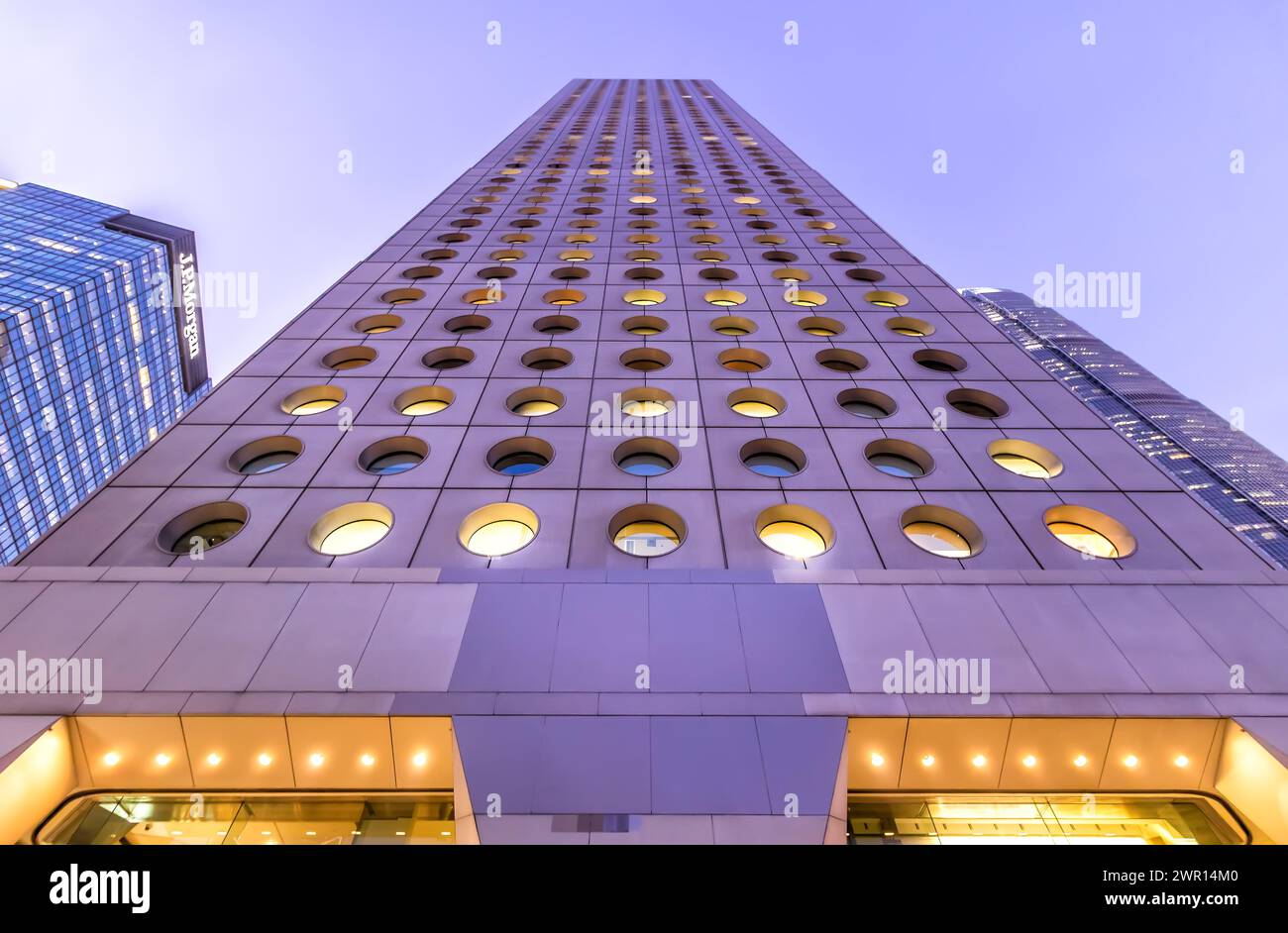 Hong Kong - 6 febbraio 2018 - Vista ad angolo basso dell'alto grattacielo, Jardine House sotto il colorato cielo viola al tramonto Foto Stock