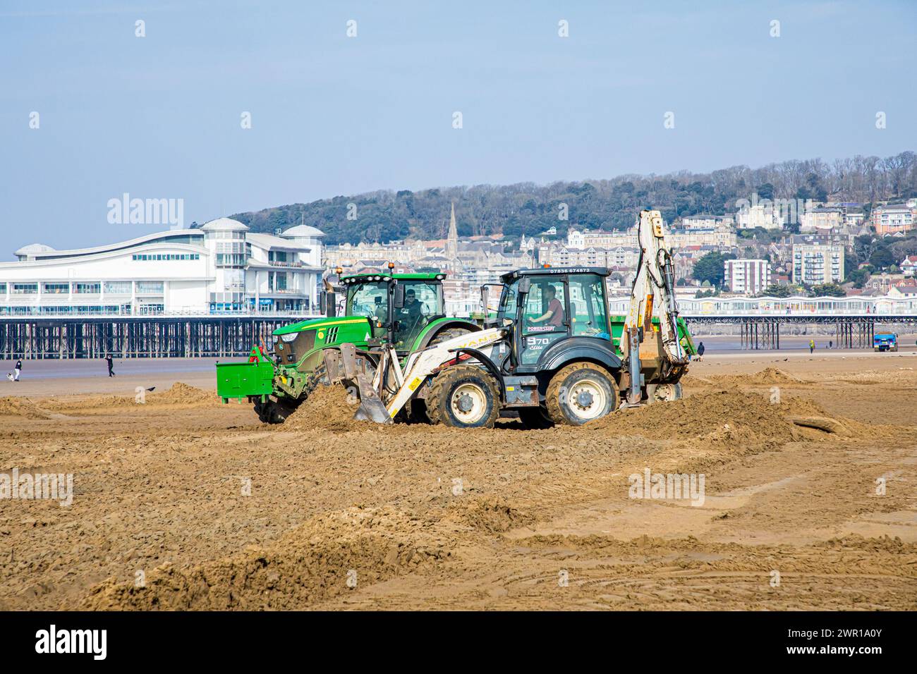Sabbia mobile di trattori e rimorchi a Weston Super Mare Beach per combattere l'effetto della deriva a lunga costa prima della stagione estiva Foto Stock