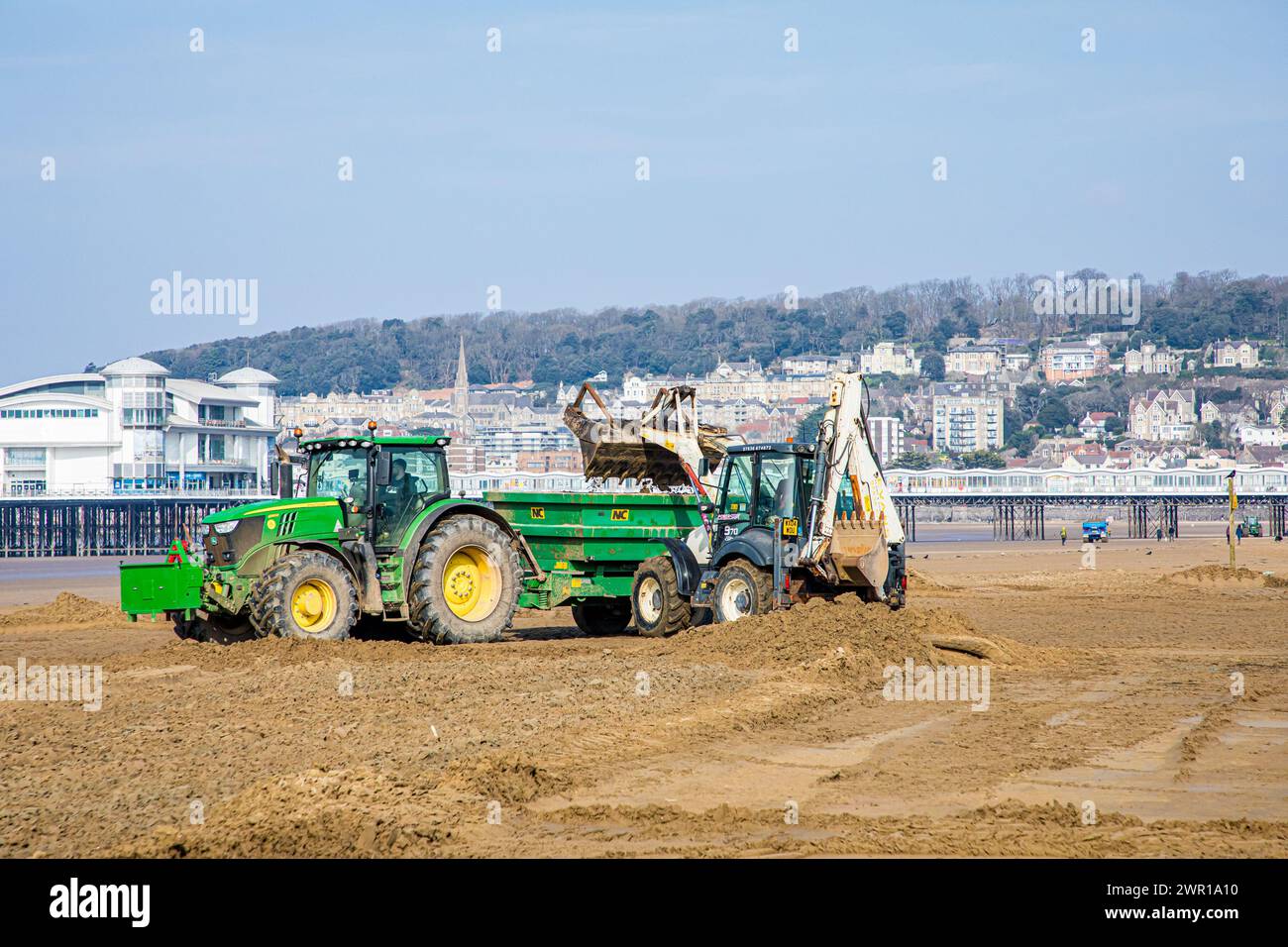 Sabbia mobile di trattori e rimorchi a Weston Super Mare Beach per combattere l'effetto della deriva a lunga costa prima della stagione estiva Foto Stock