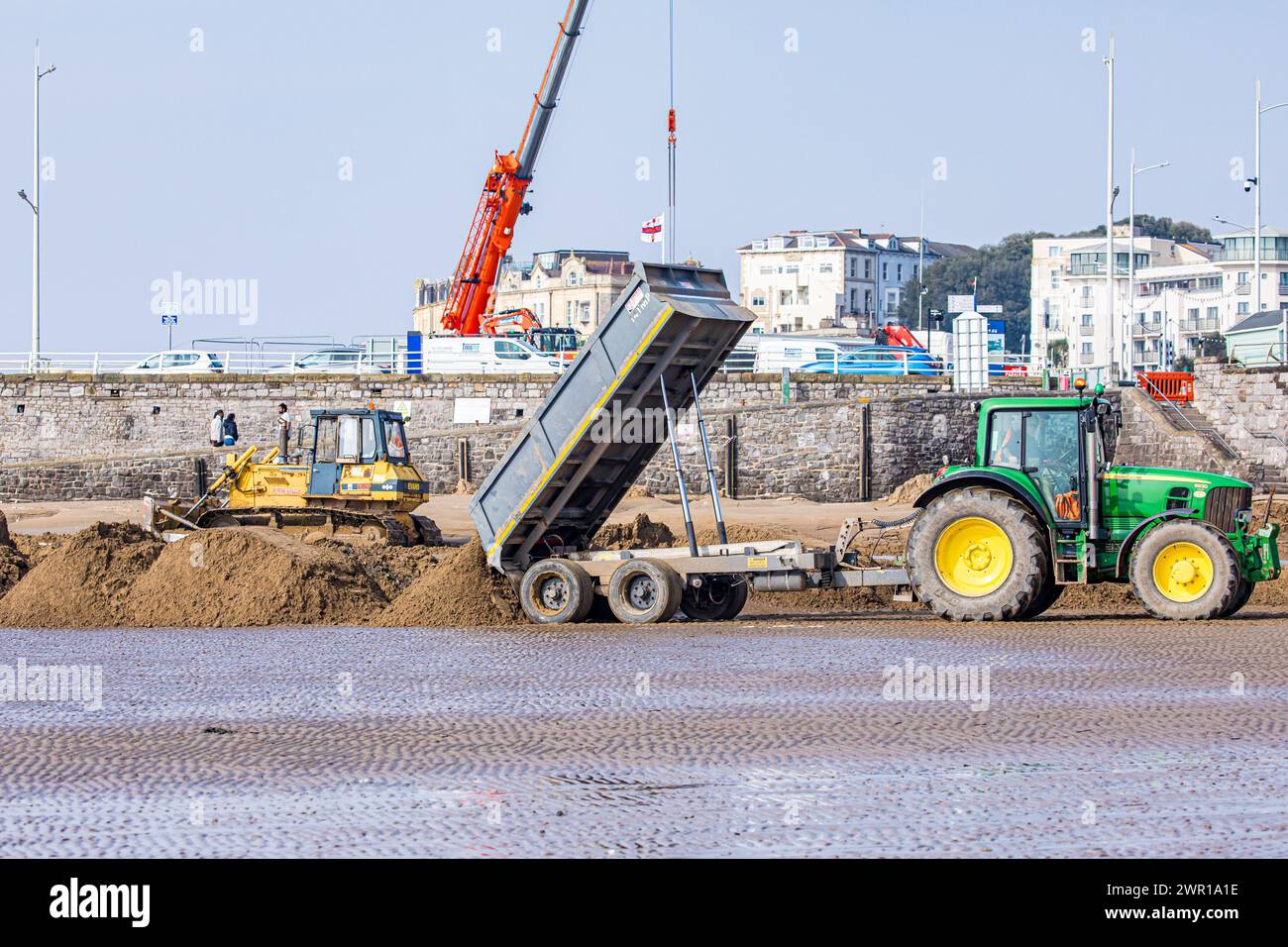 Bulldozer e trattore che si muovono sulla sabbia di Weston Super Mare Beach per combattere l'effetto della deriva lungo la costa prima della stagione estiva Foto Stock