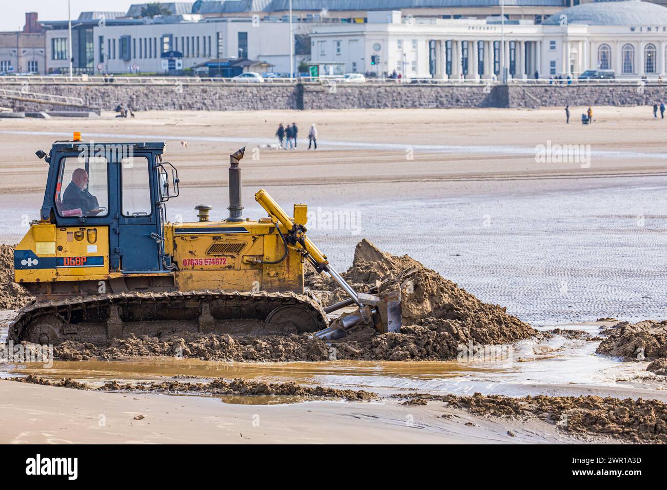 Sabbia mobile bulldozer a Weston Super Mare Beach per combattere l'effetto della deriva lungo la costa prima della stagione estiva Foto Stock