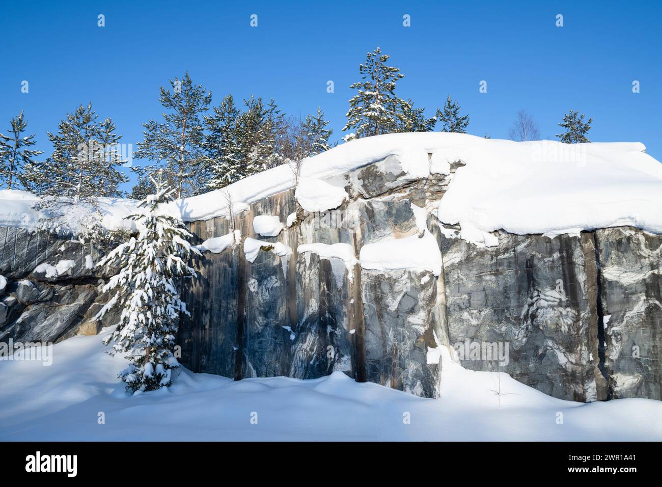 Muro di marmo di una vecchia cava in un giorno gelido di gennaio. Ruskeala Mountain Park. Carelia, Russia Foto Stock