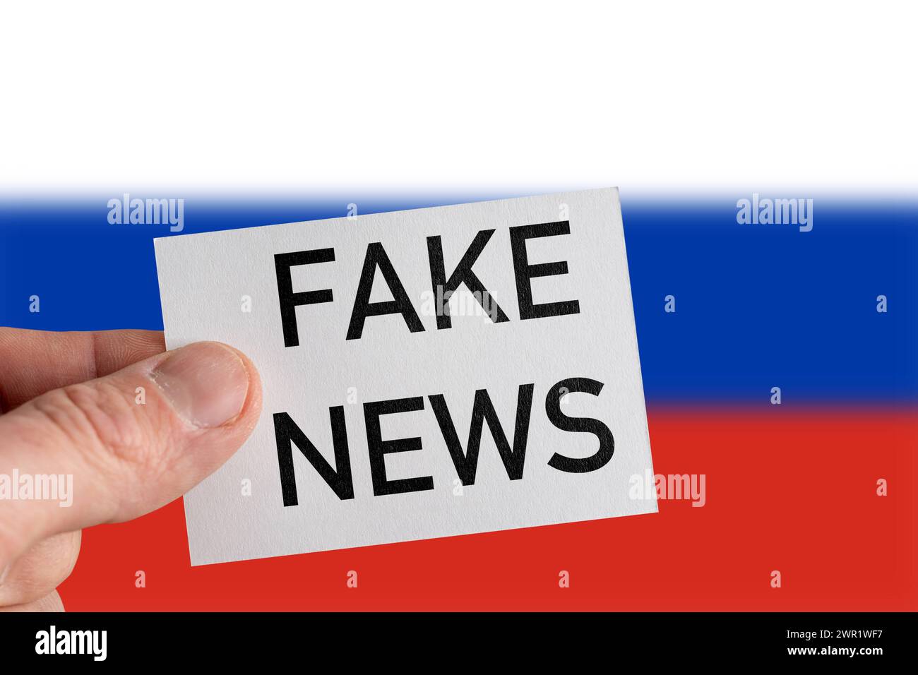 10 marzo 2024: Mano di fronte alla bandiera russa e all'iscrizione Fake News. FOTOMONTAGGIO *** mano vor Russland-Fahne und Aufschrift Fake News. FOTOMONTAGE Foto Stock