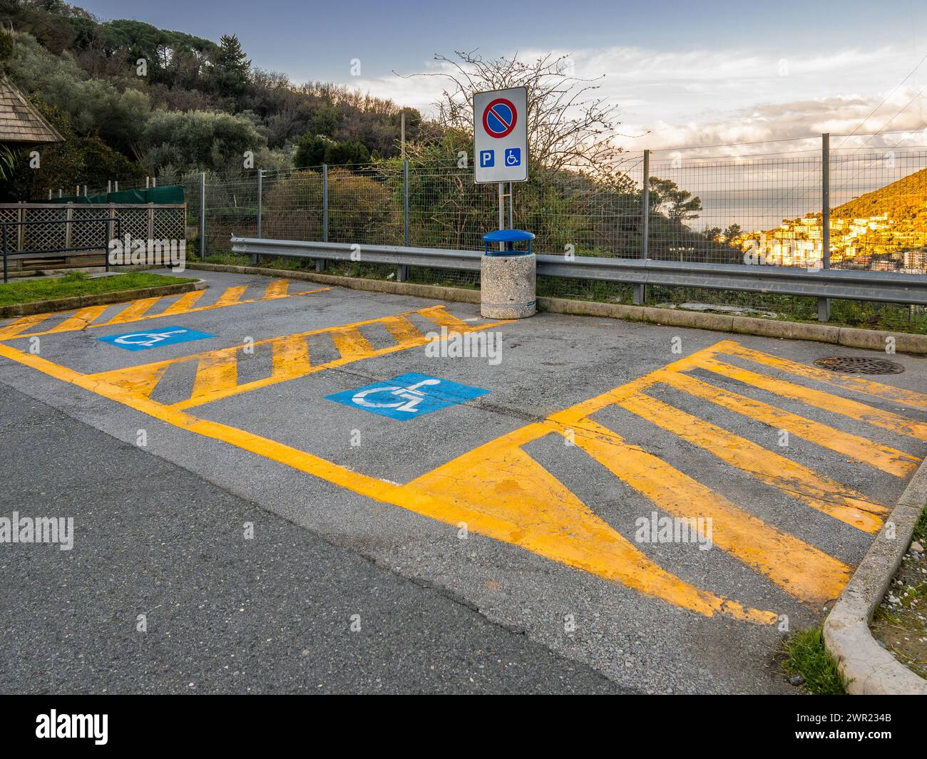 Parcheggio riservato ai disabili con linee gialle nell'area di parcheggio italiana Foto Stock