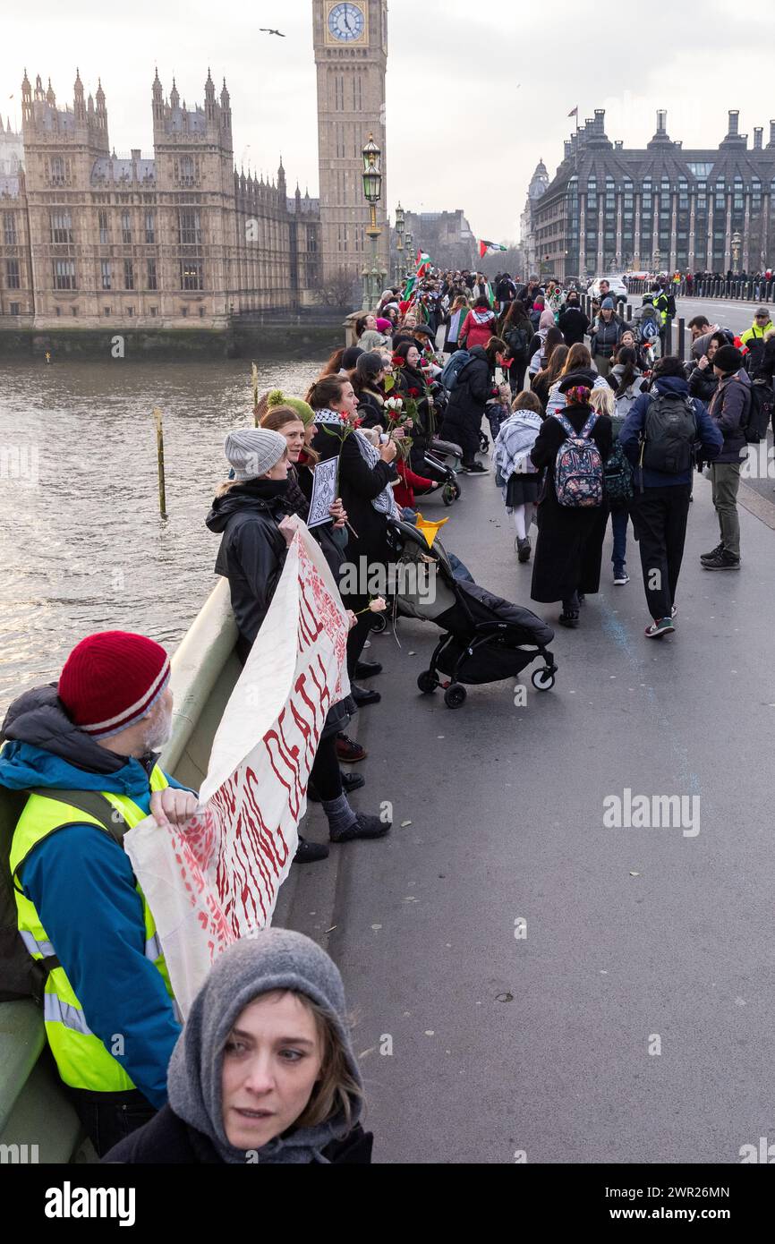 Londra, Regno Unito. 8 marzo 2024. Donne, bambini e alleati partecipano a un'azione della giornata internazionale della donna organizzata da gruppi che includono genitori per la Palestina, genitori per il futuro Regno Unito, famiglie della ribellione dell'estinzione e sciopero globale delle donne in solidarietà con le donne e le persone che nascono in Palestina. L'azione comprendeva un raduno di fronte al monumento commemorativo di Mary Seacole all'ospedale di St Thomas, un incontro di mani attraverso il ponte di Westminster e la posa di fiori su un gigantesco burattino incinta Mother Sunbird in Parliament Square. Crediti: Mark Kerrison/Alamy Live News Foto Stock