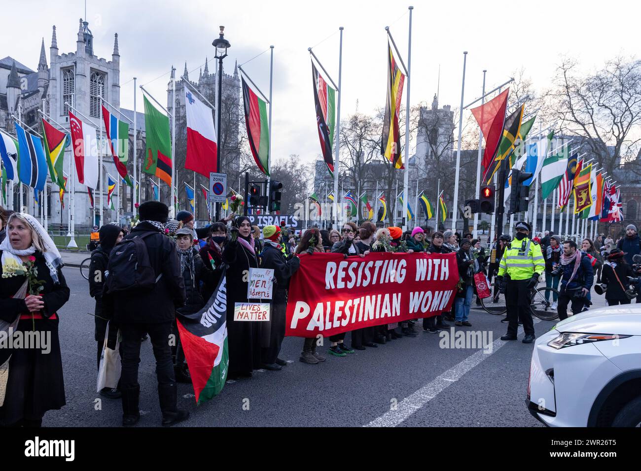 Londra, Regno Unito. 8 marzo 2024. Le donne bloccano il traffico in Parliament Square durante un'azione della giornata internazionale della donna organizzata da gruppi tra cui genitori per la Palestina, genitori per il futuro Regno Unito, famiglie della ribellione dell'estinzione e sciopero globale delle donne in solidarietà con le donne e le persone che partoriscono in Palestina. L'azione comprendeva un raduno di fronte al monumento commemorativo di Mary Seacole all'ospedale di St Thomas, un incontro di mani attraverso il ponte di Westminster e la posa di fiori su un gigantesco burattino incinta Mother Sunbird in Parliament Square. Crediti: Mark Kerrison/Alamy Live News Foto Stock