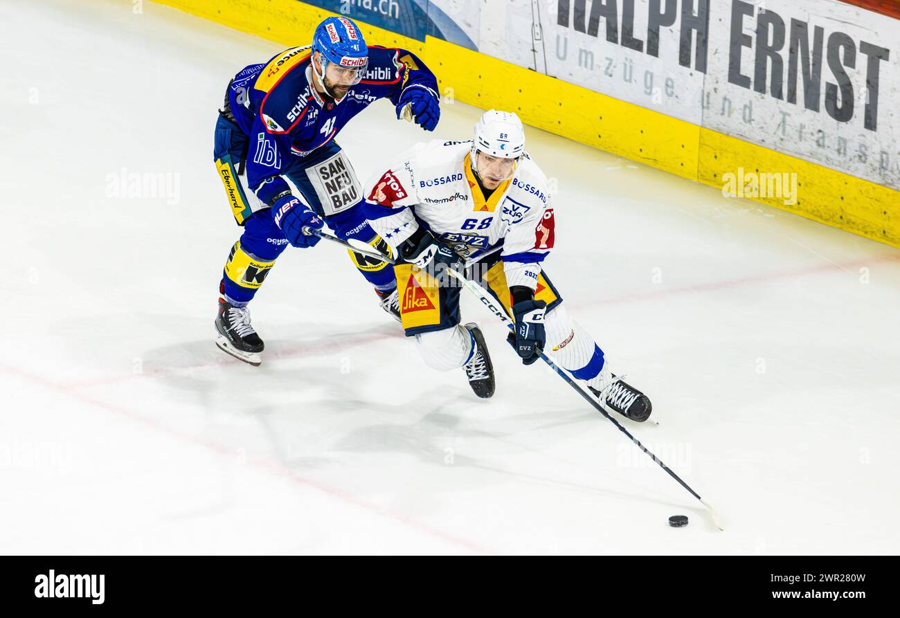 EHC Kloten - EV Zug, Stimo Arena, National League NL, stagione regolare: Stürmer #68 Fabrice Herzog (Zug) deckt den Puck gegen Verteidiger #41 Leandro Pr Foto Stock