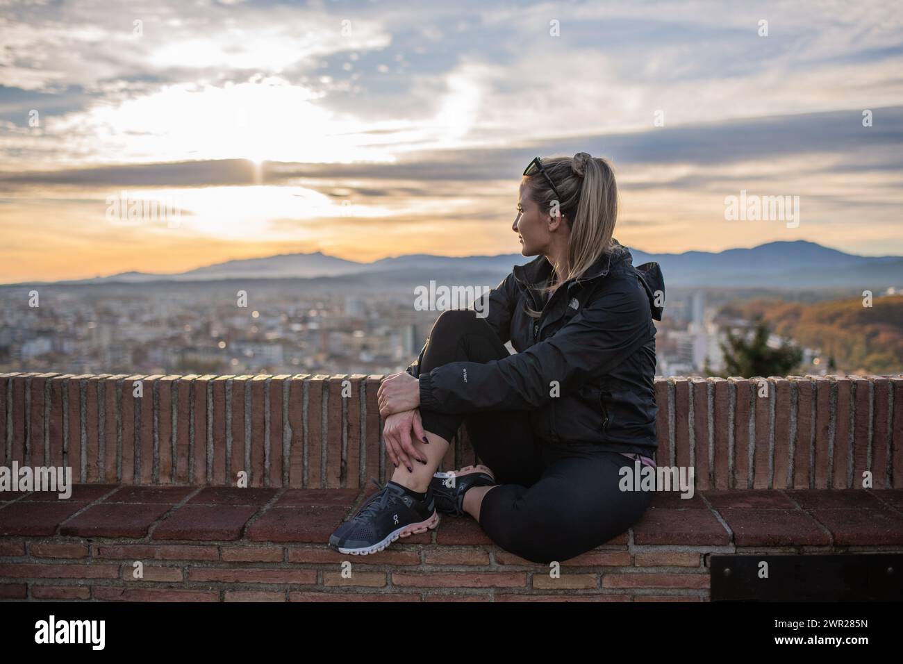 Donna che gode della vista della città di Girona da un punto panoramico alle Muralles de Girona Foto Stock