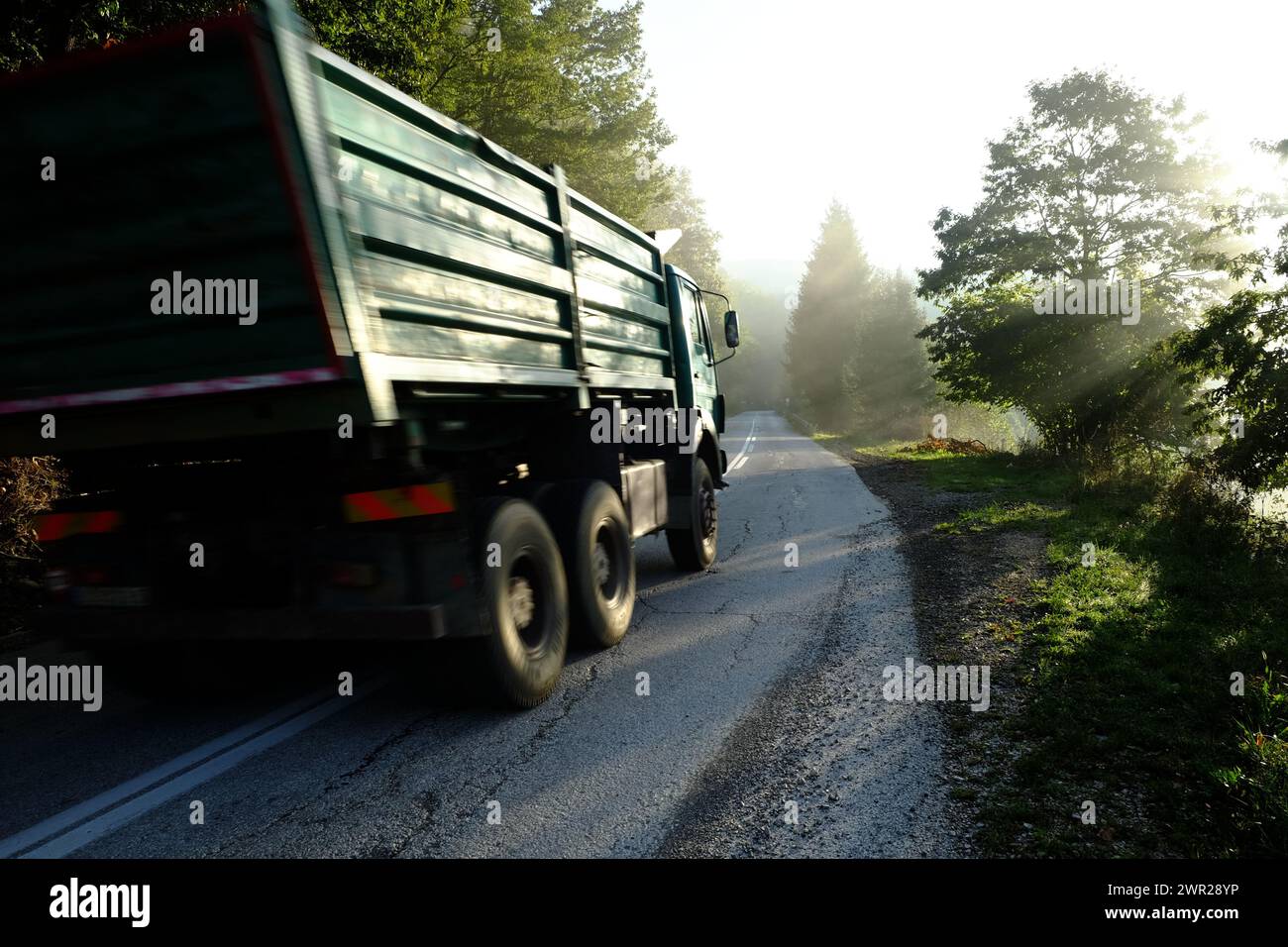 Il movimento sfoca il vecchio camion europeo alla luce del sole su una strada serba Foto Stock