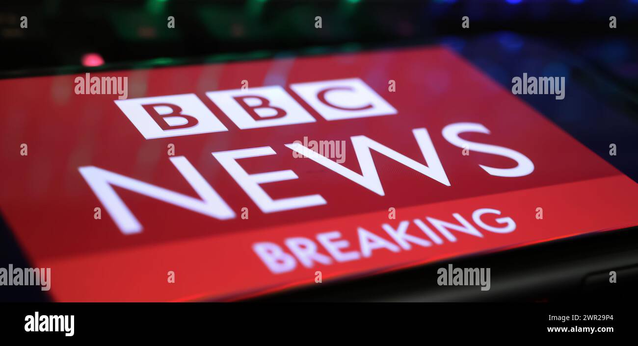 Viersen, Germania - 1 marzo. 2024: Primo piano dello smartphone con logo di BBC Breaking News sulla tastiera del computer Foto Stock