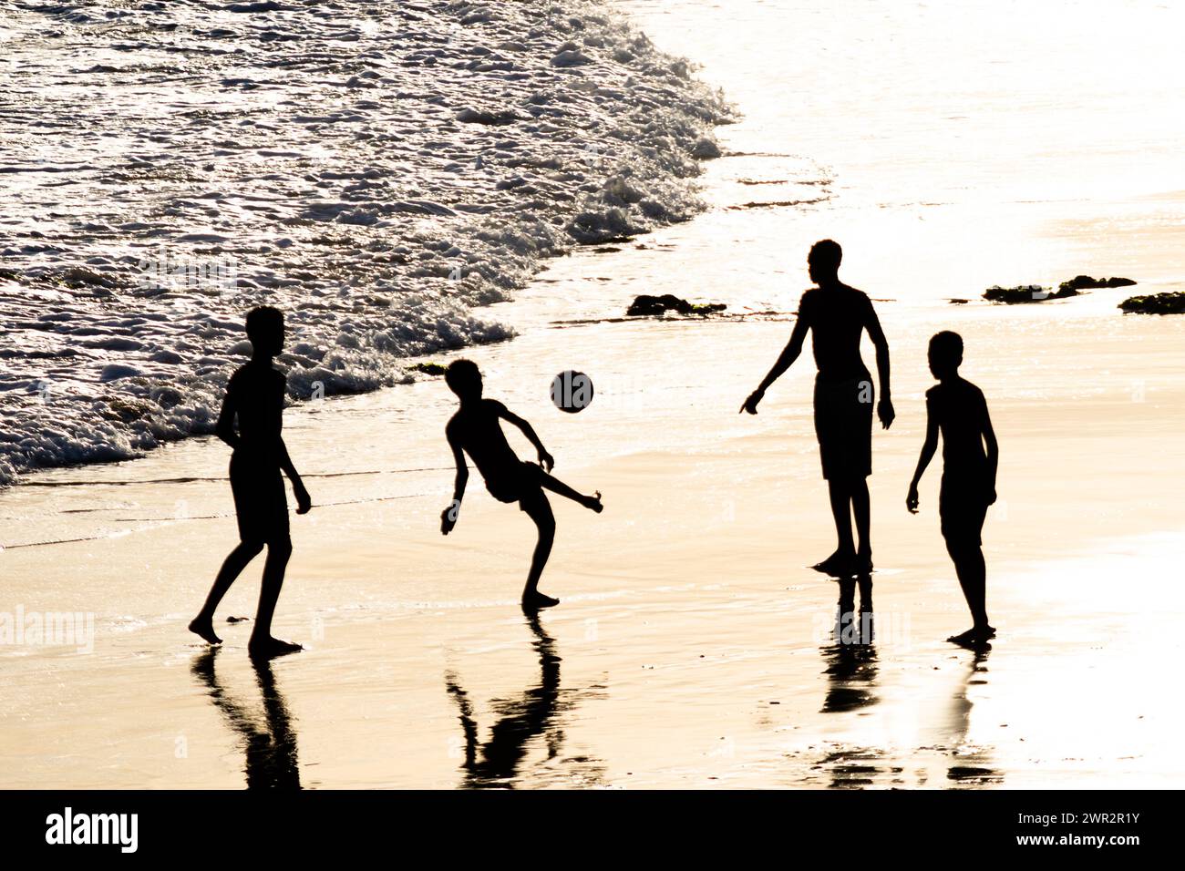 Salvador, Bahia, Brasile - 14 febbraio 2019: I giovani vengono visti, in silhouette, giocare a Beach Soccer nella città di Salvador, Bahia. Foto Stock