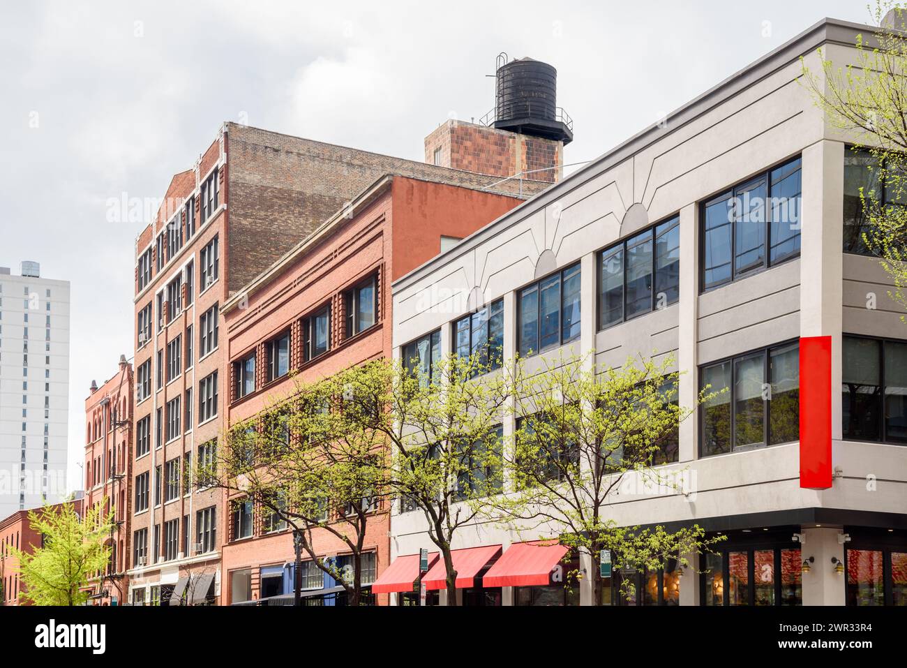 Vecchi edifici convertiti con spazio commerciale al piano terra lungo una strada a Chicago in una nuvolosa giornata primaverile Foto Stock