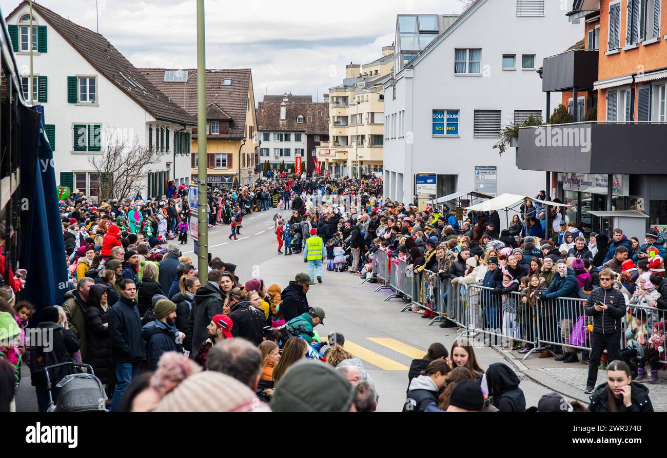 Entlang der Klotener Strasse haben sich tausende Menschen versammelt um den Bassersdorfer Fasnachtsumzug zu sehen. Es ist der erste Umzug seit drei Ja Foto Stock