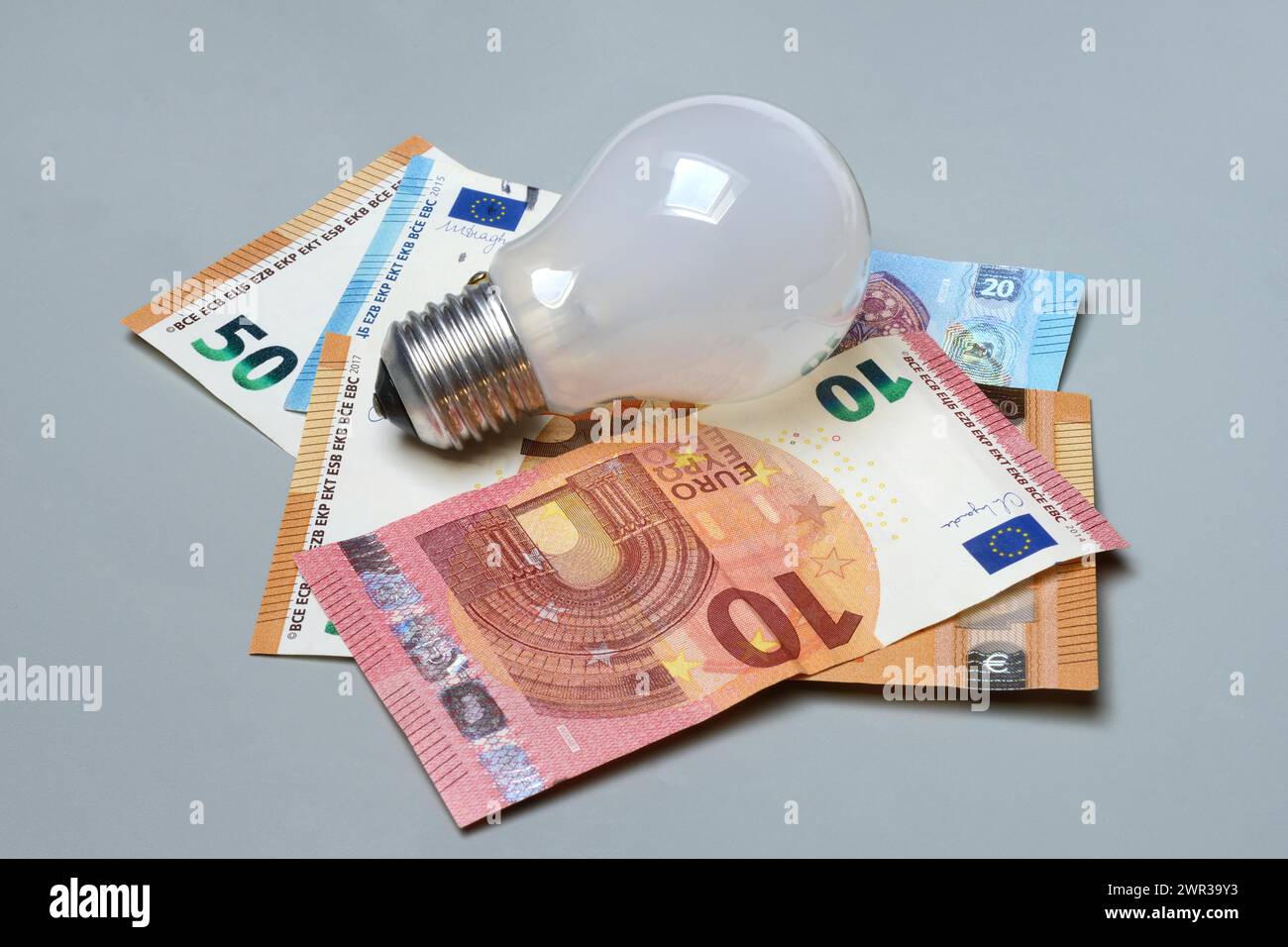 Banconote e lampadine, costi dell'elettricità Foto Stock