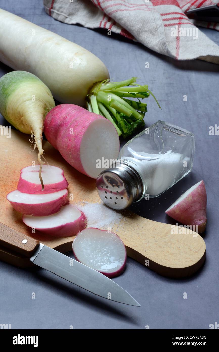 Vari raggi su una tavola di legno, tagliati e tagliati a fette Foto Stock