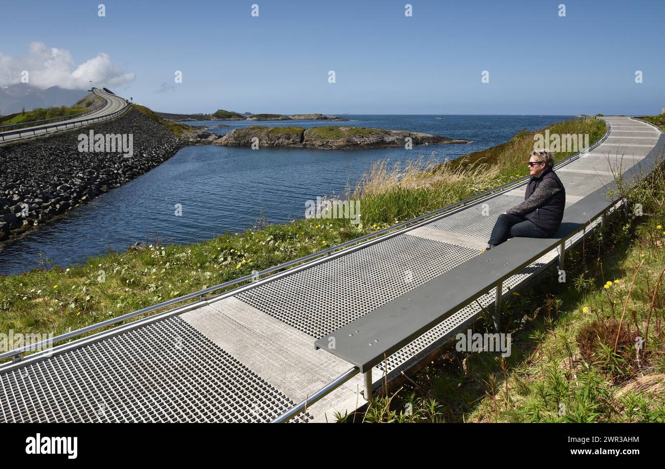 Donna seduta in un arcipelago sulla Atlantic Road in Norvegia Foto Stock