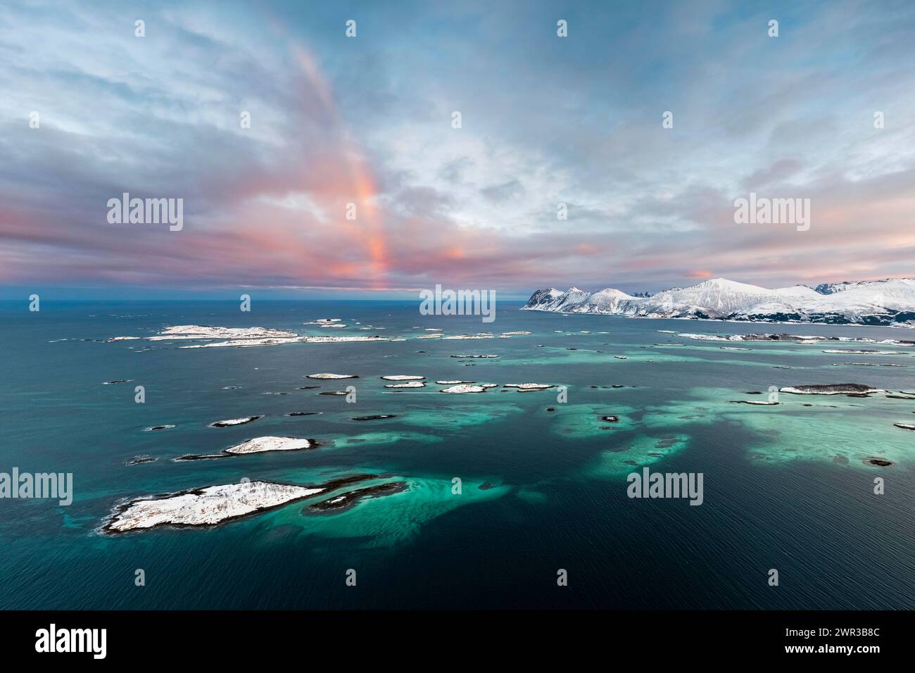 Montagne innevate dal fiordo e dalle isole, Bergsfjorden, Senja Island, Norvegia Foto Stock