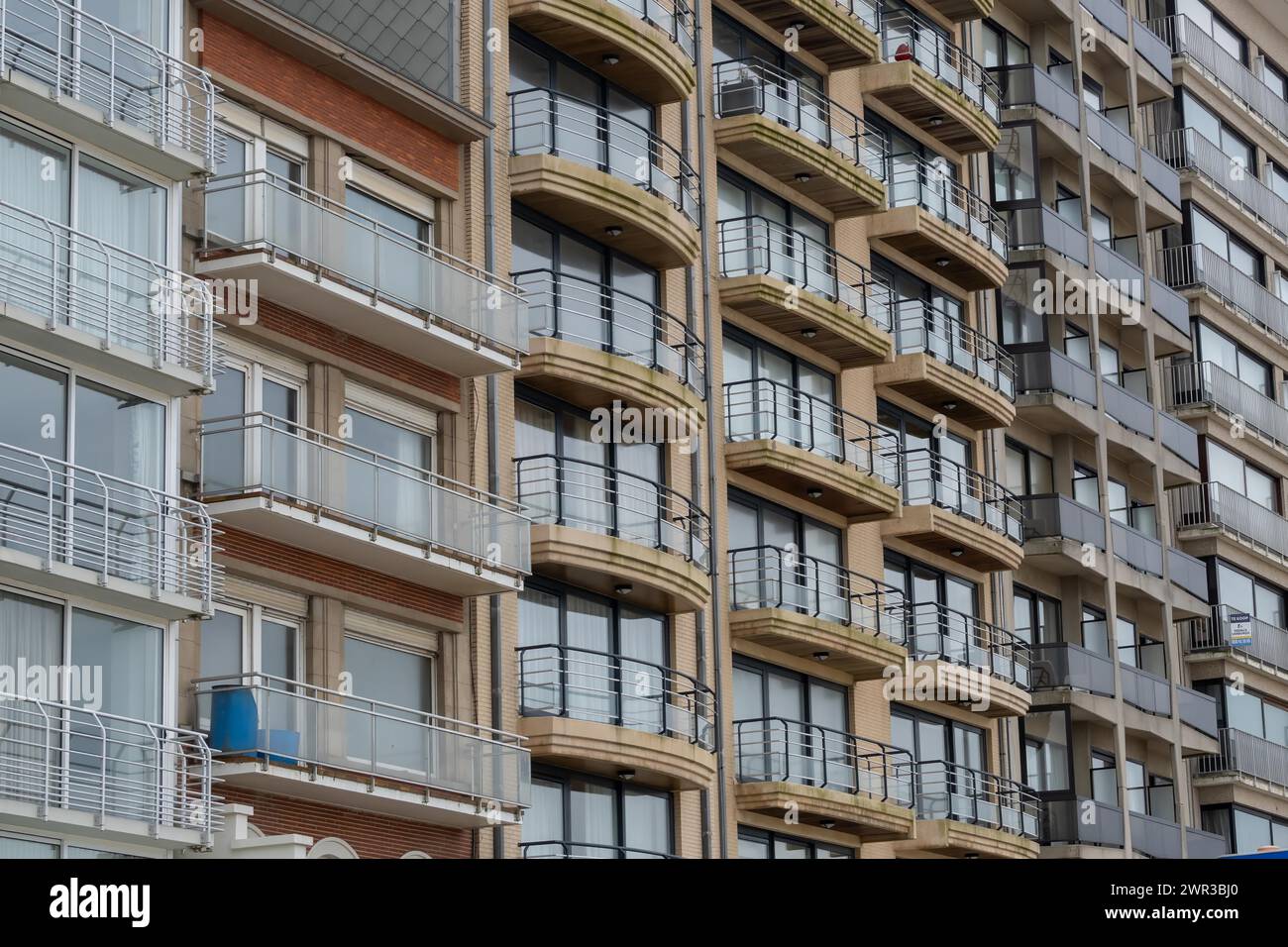 Primo piano di un edificio a più piani con balconi e facciata in mattoni, Blankenberge, Fiandre, Belgio Foto Stock