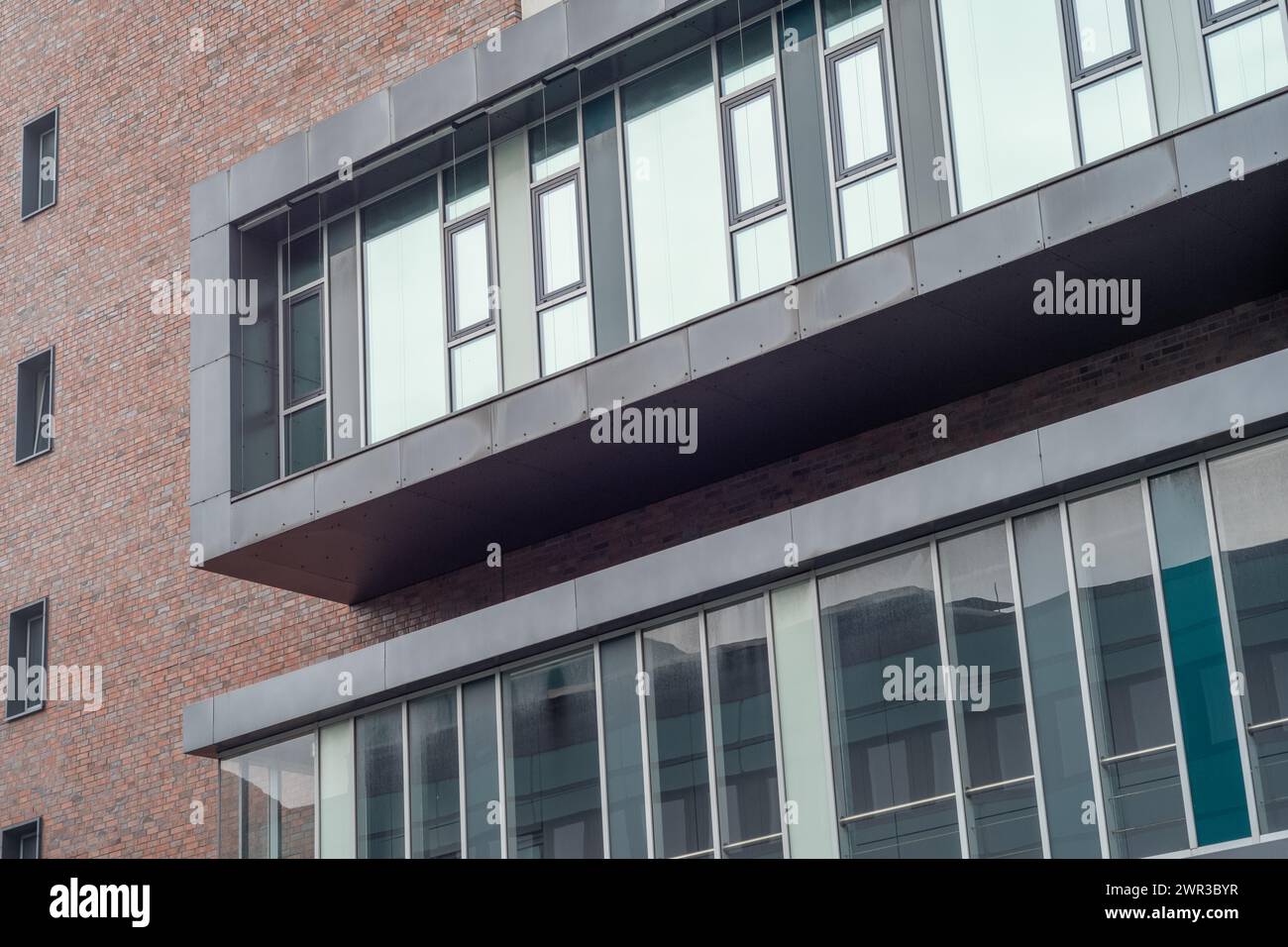 Una sezione di architettura moderna con finestre e un balcone in vetro e acciaio Foto Stock