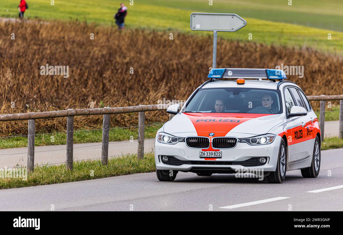 Ein Patrouillienfahrzeug der Kantonsfahrzeug der Fahrzeugmarke BMW fährt mit zwei Polizistinnen auf einer Strasse ausserorts im Zürcher Unterland. (OST Foto Stock