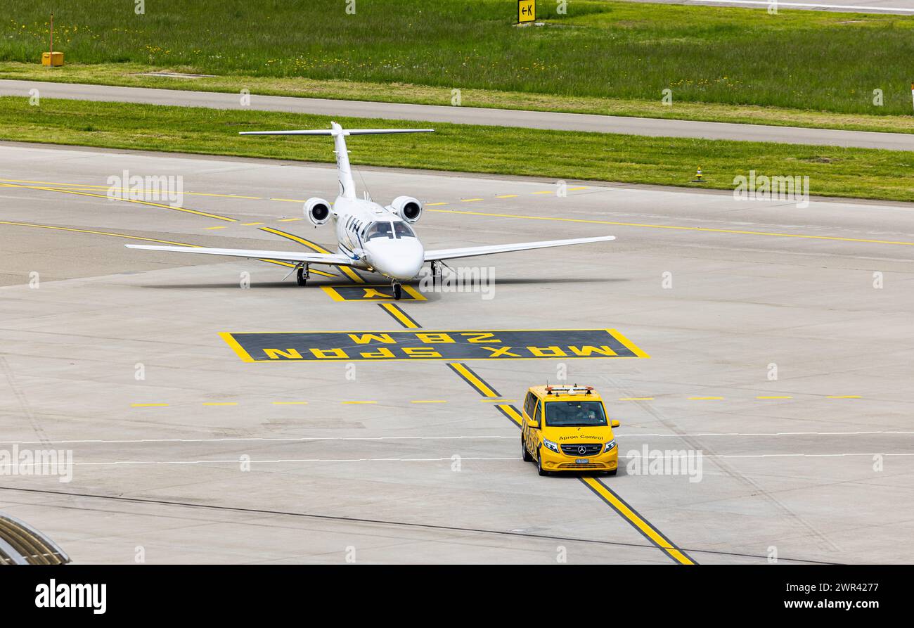 Ein Embraer Phenom 100 wird nach der Landung auf dem Flughafen Zürich von einem Bodenlotsen zum Standplatz geführt. (Zürich, Svizzera, 07.05.2023) Foto Stock