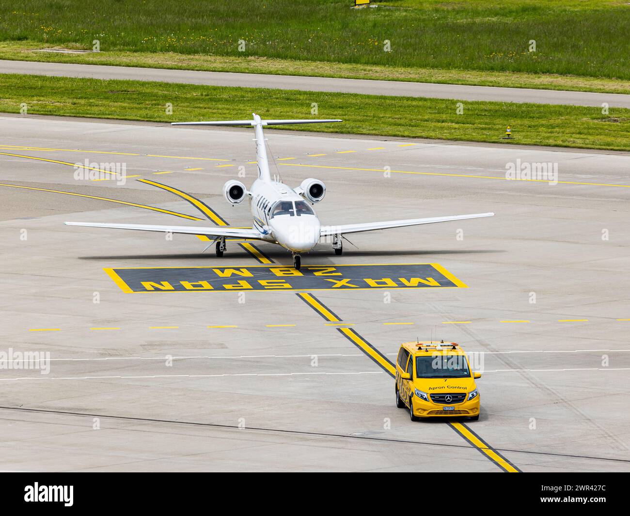 Ein Embraer Phenom 100 wird nach der Landung auf dem Flughafen Zürich von einem Bodenlotsen zum Standplatz geführt. (Zürich, Svizzera, 07.05.2023) Foto Stock