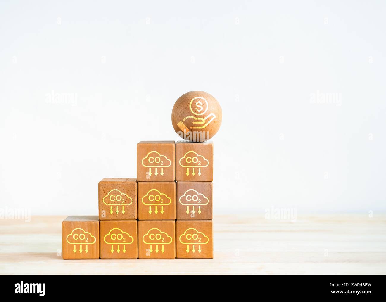 Concetto di credito di carbonio e riduzione delle emissioni di CO2. Icona del risparmio sui costi sulla sfera di legno sopra i gradini dei blocchi di legno come grafico di crescita aziendale con carbonio e. Foto Stock