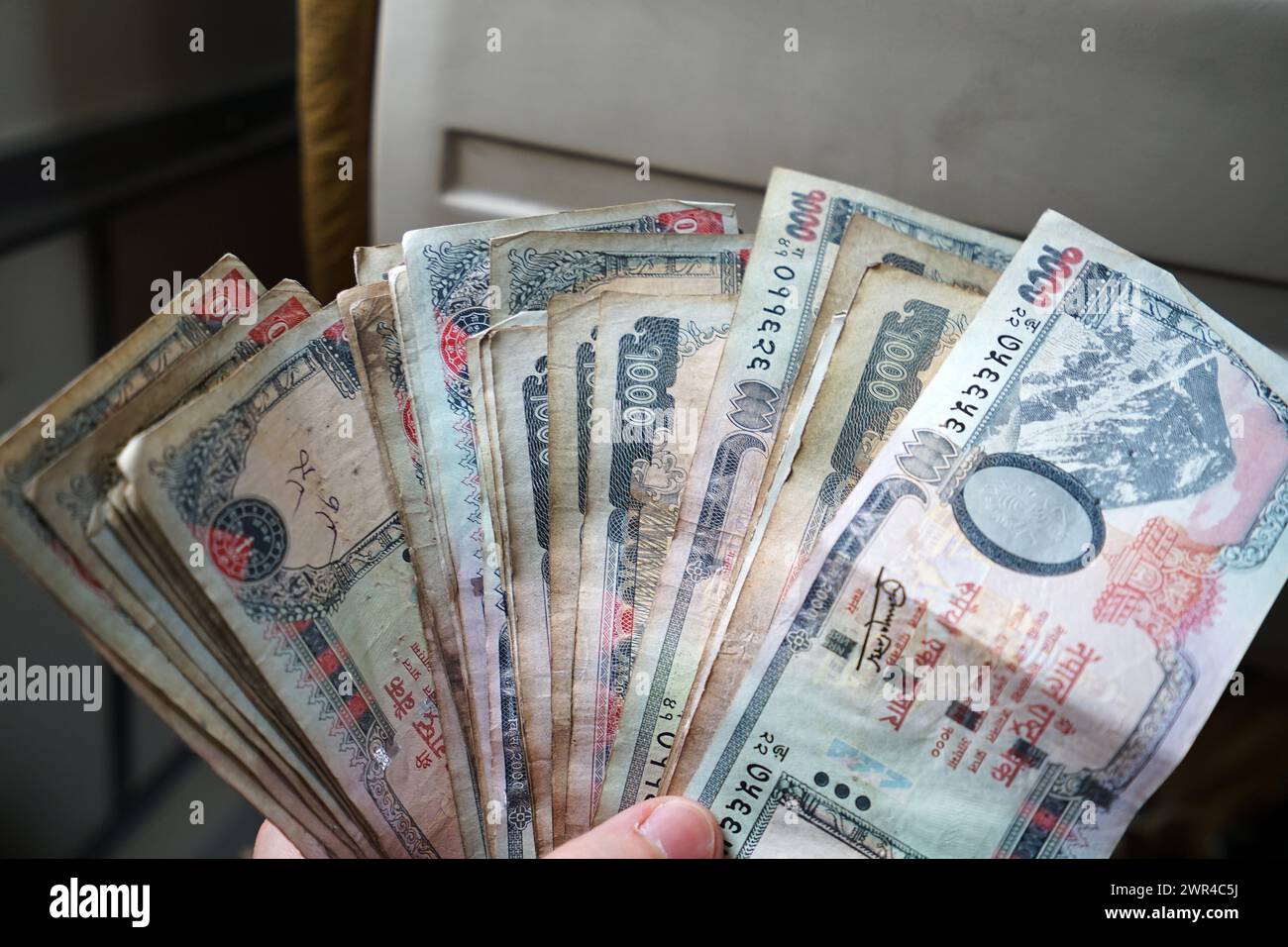 Mano con banconote in rupie nepalesi - valuta nazionale nepalese Foto Stock