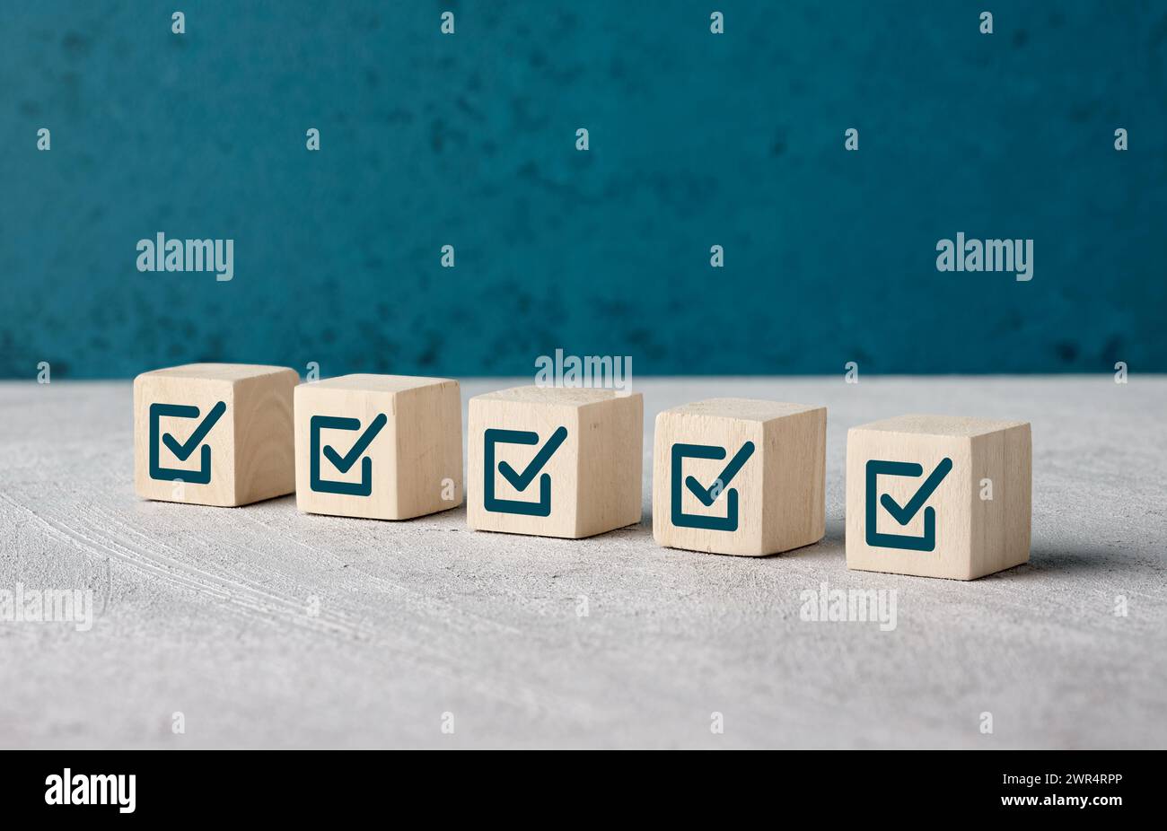 Simboli delle caselle di controllo sui cubi di legno. Per completare l'elenco delle attività e l'attività. Processo di controllo qualità. Elenco di controllo sondaggio e valutazione. Foto Stock