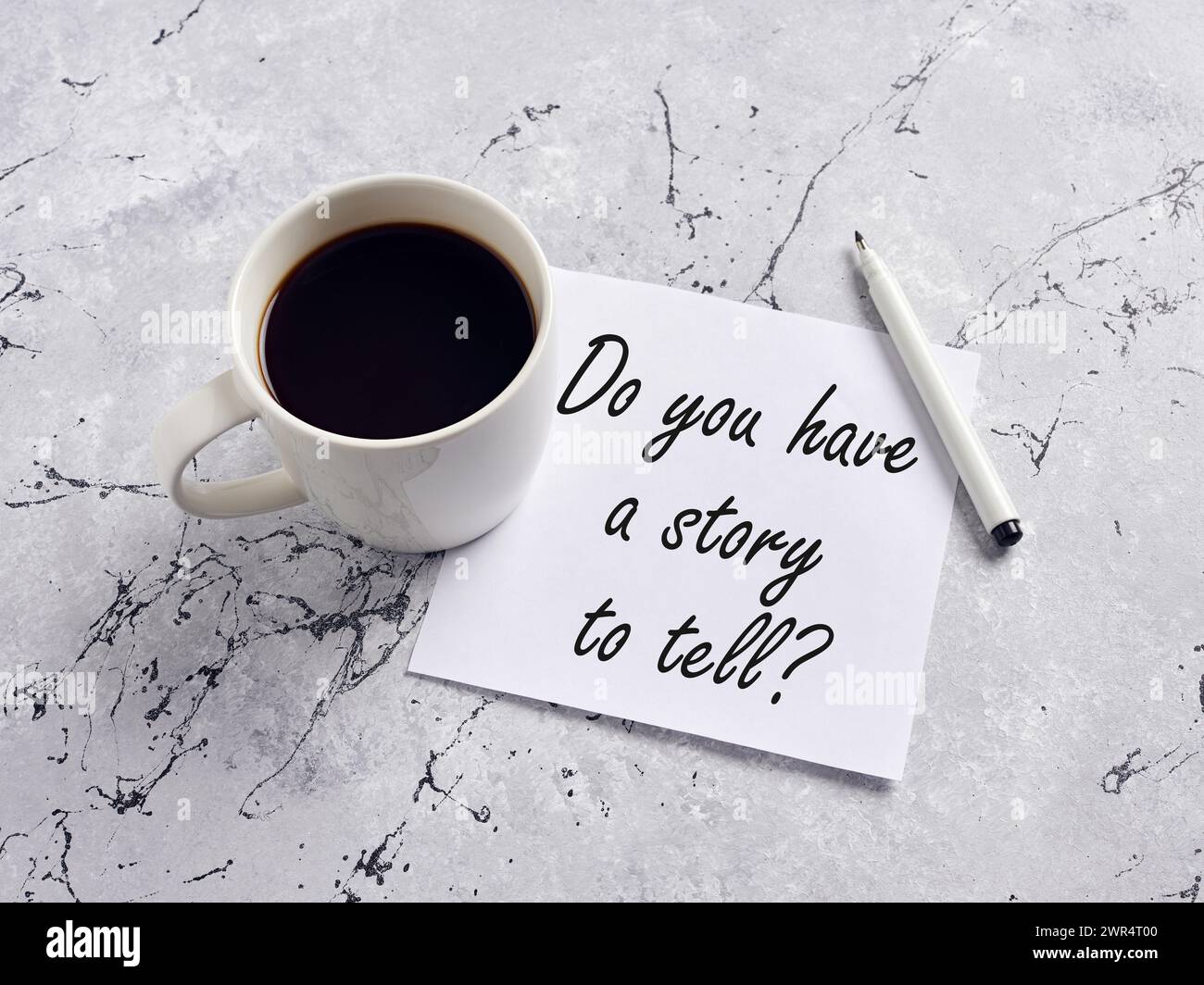 La domanda hai una storia da raccontare scritta a mano su un foglio con penna e tazza da caffè su un tavolo. Storytelling e condivisione di esperienze. Foto Stock