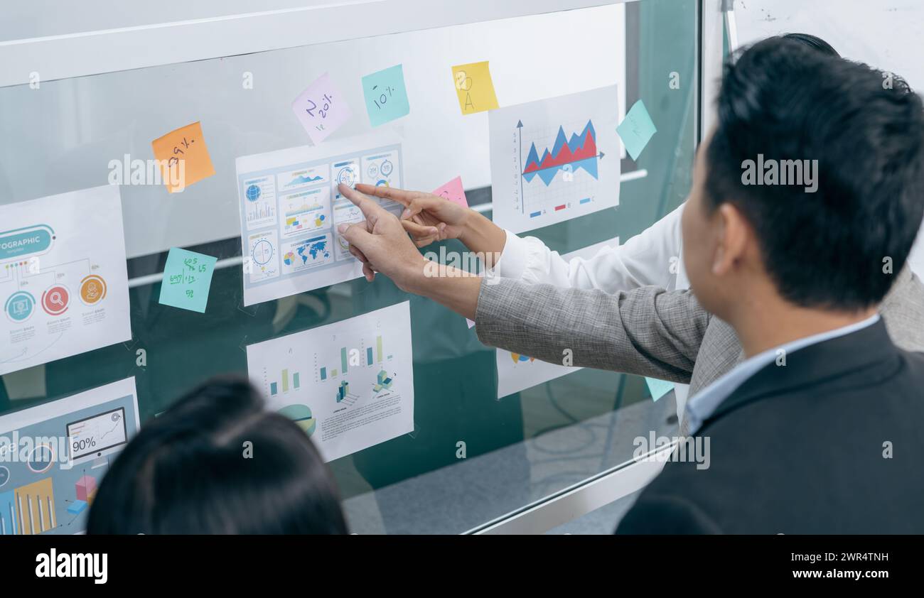 Un uomo e una donna guardano una tavola con grafici e numeri Foto Stock