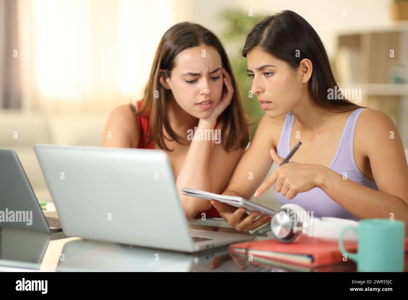 Due studenti preoccupati studiano online a casa Foto Stock